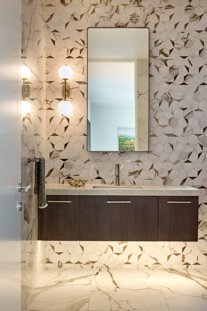 Guest bathroom details with gold mosaic tiles and brass lighting details, new house